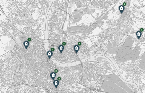 Schwarz-weiss gestaltete, topographische Karte der Stadt Basel sowie der angrenzenden Gebiete in Deutschland und Frankreich. Auf der Karte sind die verschiedenen Polizeiwachen und Polizeiposten des Kantons Basel-Stadt mit Hilfe von Icons markiert.