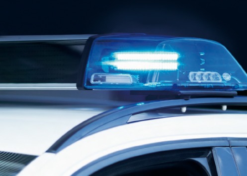 Eingeschaltetes Blaulicht eines stehenden Polizeifahrzeuges in Grossaufnahme.