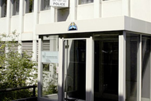 Von der Sonne beschienener, gläsernen Eingangsbereich des Stützpunktes der Autobahnpolizei. Über dem Eingang weist ein Schild mit der Aufschrift "Police" auf den Stützpunkt der Autobahnpolizei hin.   