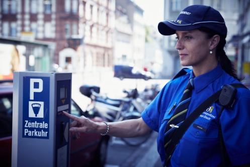 Sicherheitsassistentin der Kantonspolizei Basel-Stadt beim Bedienen einer Parkuhr in der Basler Innenstadt.